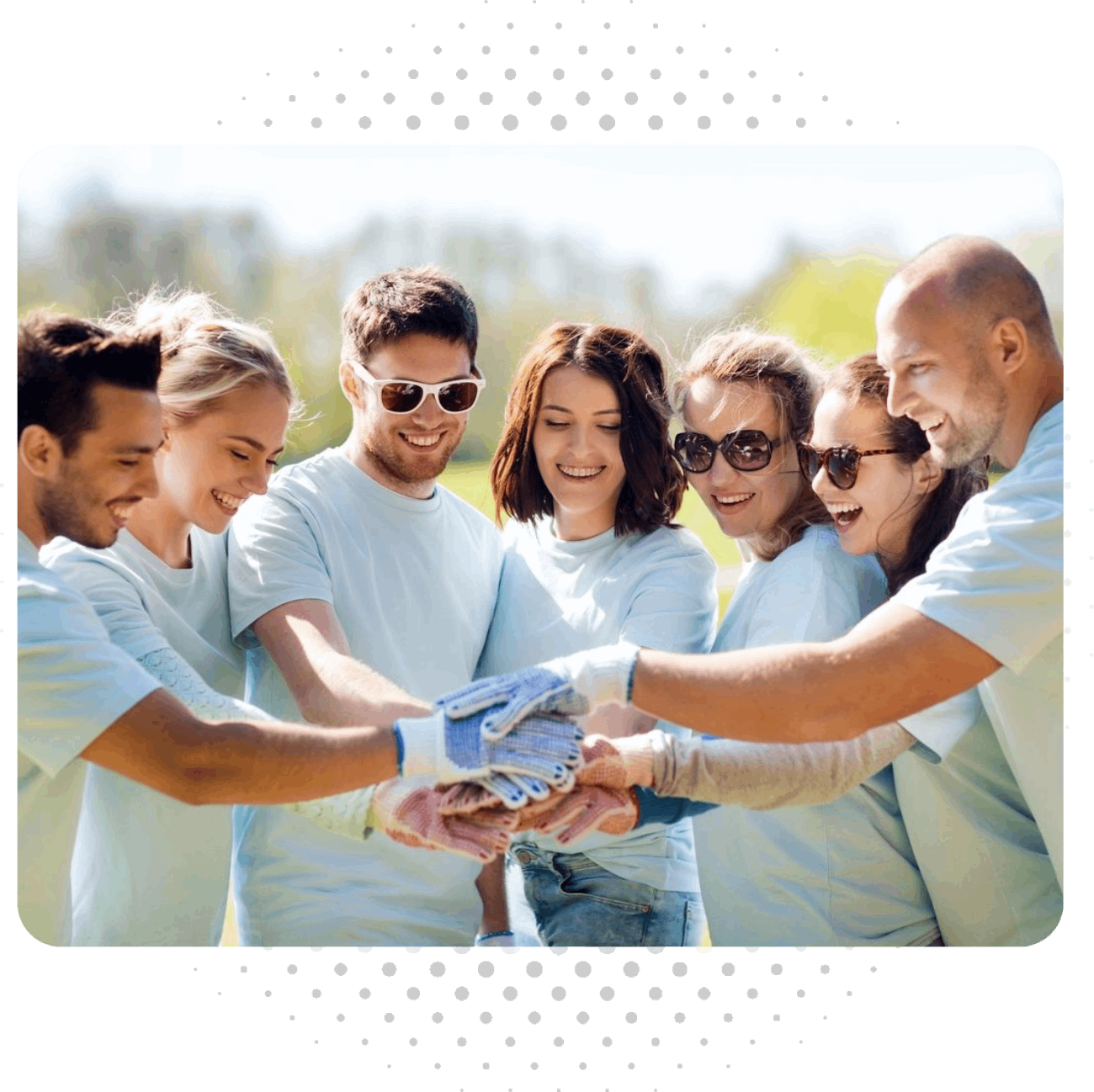 A group of people in blue shirts holding hands.